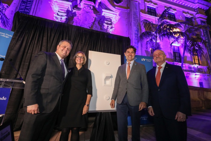 The group stands in front of the ceremonial light switch used to light the tower