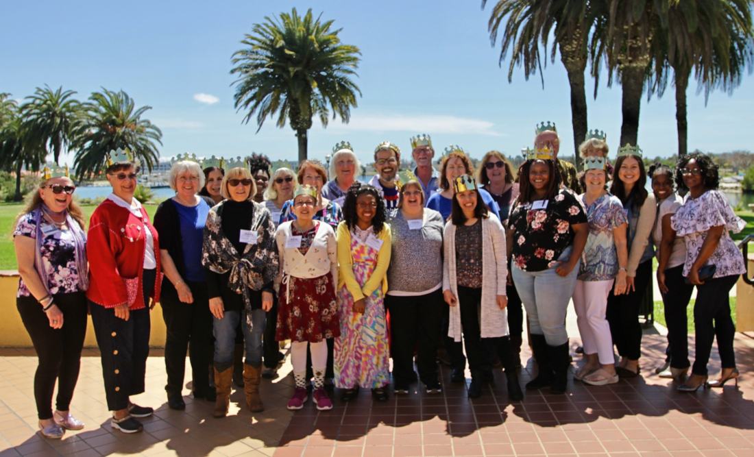 Alex Silva with a group of VITAS volunteers wearing crowns