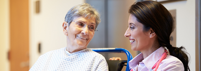 Patient in wheelchair smiles at caretaker