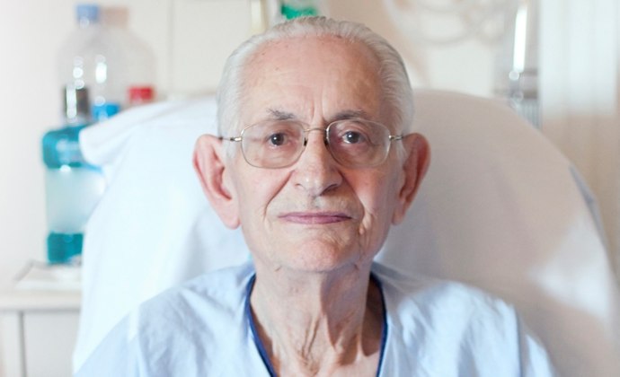 A man sits upright in bed